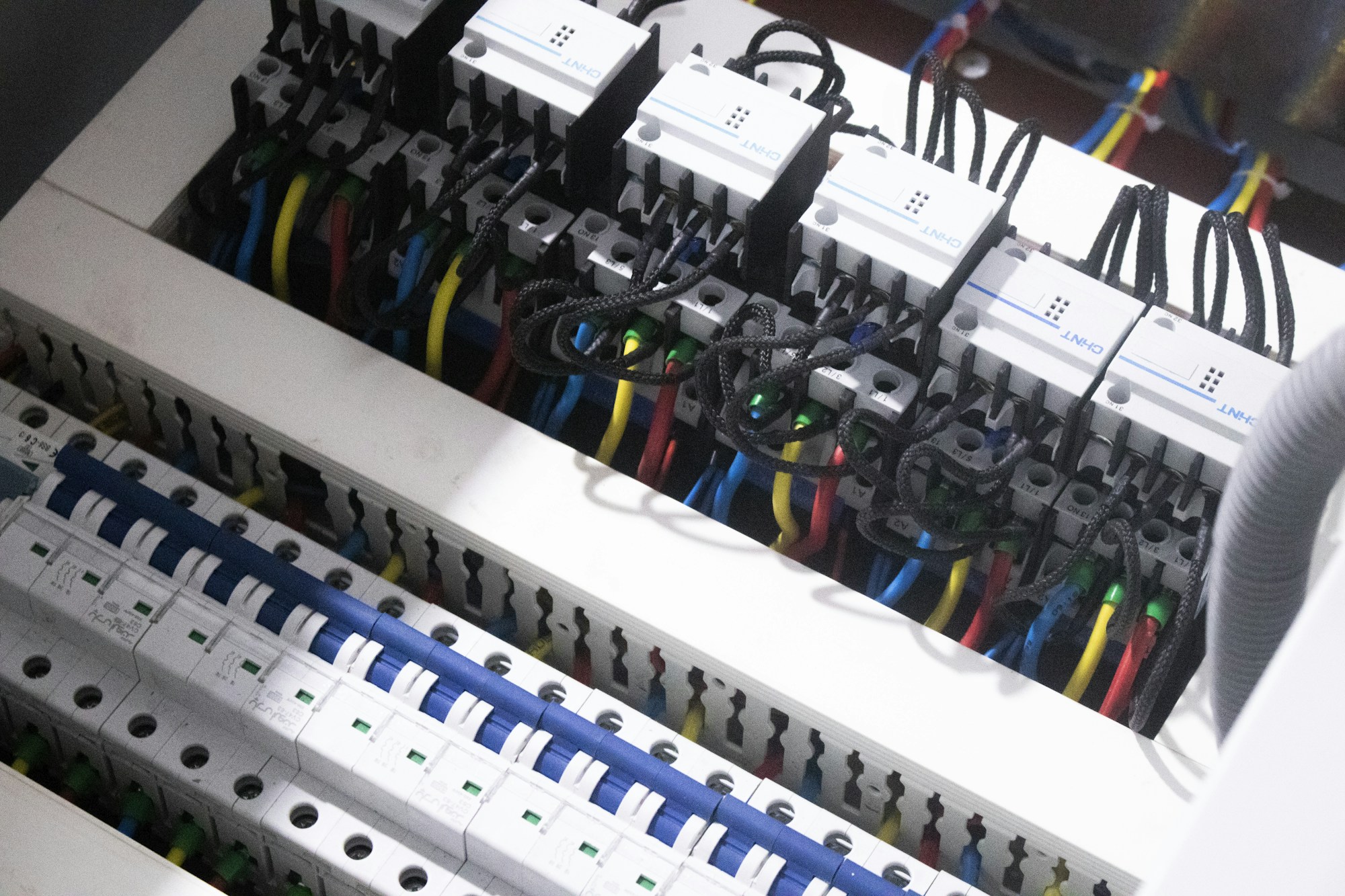 Open electrical panel with circuit breakers and color-coded wiring